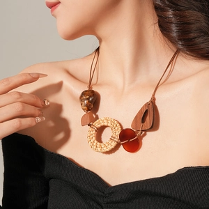 Gros plan d'un collier bohème avec rotin tressé et perles en résine ambrée
