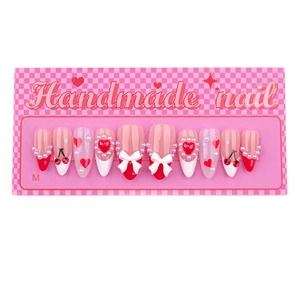Handmade press-on nails with pink base, red heart patterns, and 3D bow accents