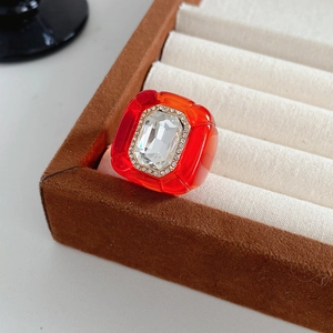 Détail macro d'une bague en résine rouge avec cristal dans un écrin à bijoux