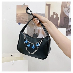 Detail of a black leather shoulder bag featuring a silver chain with blue butterfly charms