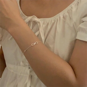 Elegant S925 sterling silver infinity bracelet with zircon stones on model's wrist