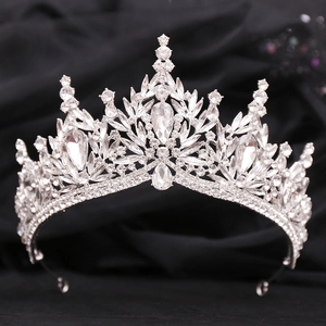 Macro shot of silver bridal crown with crystals and pear-shaped gems on black fabric
