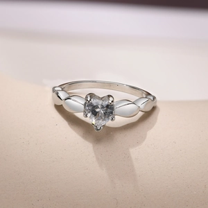 Close-up of heart-shaped zircon ring with silver leaf details and polished finish