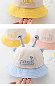 Detail of baby sun hat with cute snail embroidery and soft brim in pastel colors