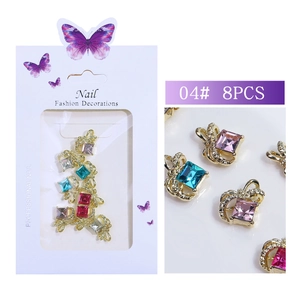 Macro view of 8-piece set of golden crown nail charms with multi-colored square rhinestones
