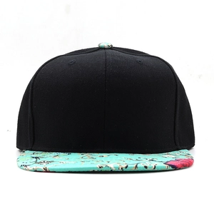 Close-up of a black snapback cap featuring a vibrant teal floral print on the flat brim