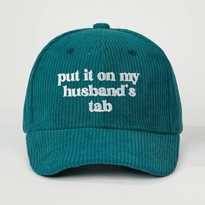 Dettaglio del cappello in velluto a coste verde scuro con ricamo bianco put it on my husband's tab