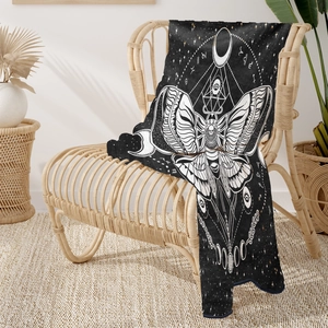 Close-up of gothic moth and moon phases pattern on soft black flannel blanket