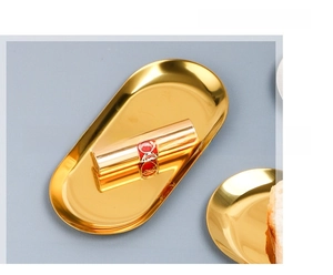 Close-up of golden stainless steel oval tray with mirror finish for desktop storage