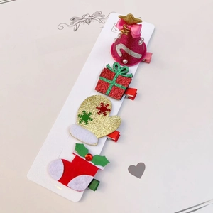 Détail de pinces à cheveux de Noël avec motifs chapeau, boîte cadeau, gant et chaussette