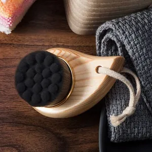 Detail of wooden facial brush with soft black fiber bristles and white hanging cotton rope
