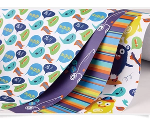 Close-up of assorted cartoon gift wrapping paper with monster and stripe patterns