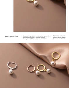 Detail of minimalist pearl earrings in gold, silver and rose gold over satin fabric