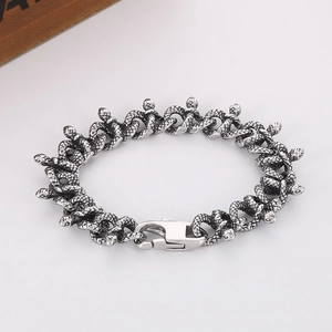 Detailed view of a silver snake chain bracelet with a polished lobster clasp and metal texture