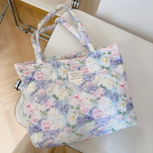Macro view of floral quilted cotton tote bag with vintage rose pattern and fabric label
