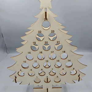 Macro detail of wooden Christmas tree countdown calendar with 24 numbered holes