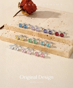 Detailed display of ten colorful round-cut S925 silver stud earrings on marble blocks