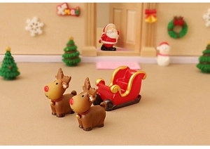 Macro detail of Christmas resin figurines featuring brown reindeer and a red sleigh car