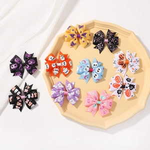 Detailed flat lay of ten Halloween bow hair clips with ghost and pumpkin patterns