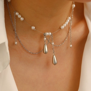 Close-up of layered necklace with white pearls and silver waterdrop shaped pendants