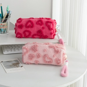 Plush heart pattern pencil case and makeup bag set with pompom charm on desk