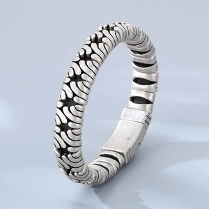 Detailed view of men's vintage stainless steel bracelet with textured ripple surface