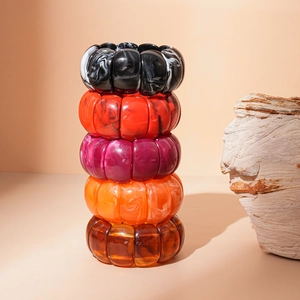 Close-up of stacked geometric acrylic resin bracelets with marble texture and pumpkin ribbing