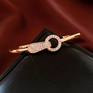 Gros plan d'un bracelet en or rose avec cercles entrelacés pavés sur cuir noir