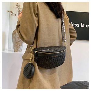 Detail of black woven crescent bag with gold zipper and detachable small round pouch