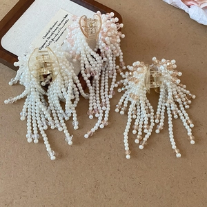 Detail of handcrafted tassel hair claw featuring faux pearls and pink crystal beads