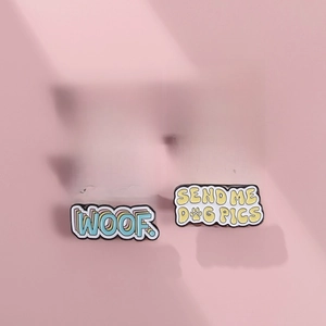 Set of 5 colorful enamel dog paw pins with funny quotes on a pink background