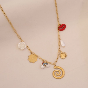 Détail d'un collier doré avec pendentifs de fleurs, perles et breloques sur fond beige