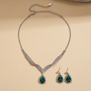 Detail of luxury teardrop emerald jewelry set with silver chain and white rhinestones