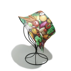 Detailed view of bucket hat with vegetable print on a minimalist black wire display stand