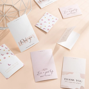 Flat lay of pink and white greeting cards with gold text for Valentine's and birthdays