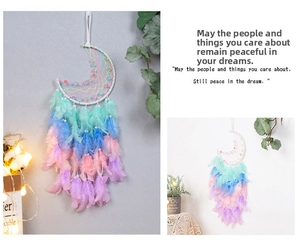 Detailed view of handmade crescent moon dream catcher with pastel feathers and beads