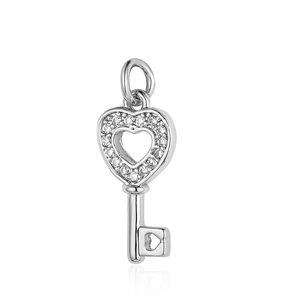 Detailed macro view of a silver heart key pendant with sparkling clear cubic zirconia