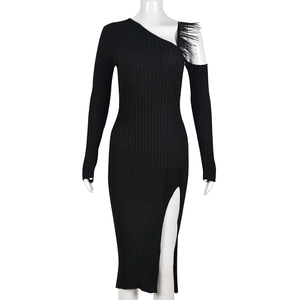 Detail of the chic black knit dress with unique feather trim and elegant one-shoulder cut