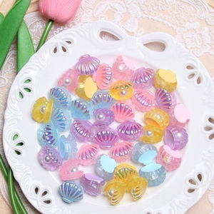 Colorful resin pearl shell DIY charms with iridescent glitter in a white lace basket