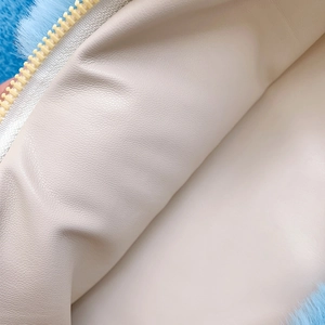 Detail view of sky blue plush bag featuring beige faux leather lining and zipper closure