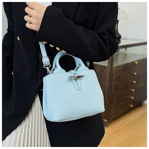 Detailed shot of light blue leather bucket bag with silver bamboo buckle and strap