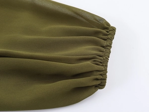 Detail shot of army green pleated chiffon sleeve with elastic cuffs and precise stitching