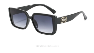 Detail of black oversized square sunglasses with gold double-ring temple and crystals