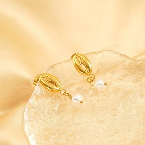 Elegant gold shell earrings with white pearl pendants on a premium silk fabric background