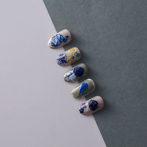 Detail of grey false nails with 3D embossed blue roses and butterfly art stickers
