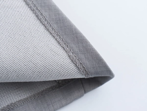 Gros plan détaillé de la texture du tissu gris et de la couture de qualité sur le vêtement