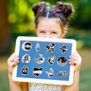 Outdoor nature stickers featuring mountains and animals held by a girl in nature