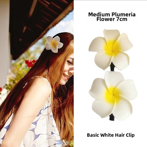 Detail view of a 7cm white and yellow plumeria flower hair clip for hair styling
