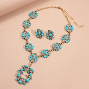 Retro gold jewelry set with blue resin stones and rhinestones featuring an oval necklace