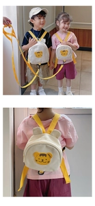 Close-up of kids canvas backpack showing safety leash and yellow bear embroidery